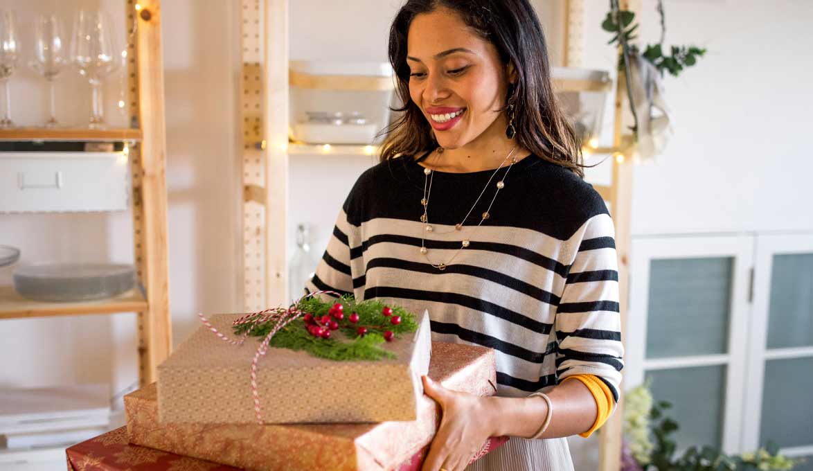 Woman carrying holiday gifts.